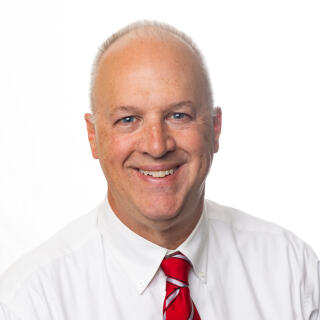 David Wirt, a White man in a white dress shirt and red striped tie.