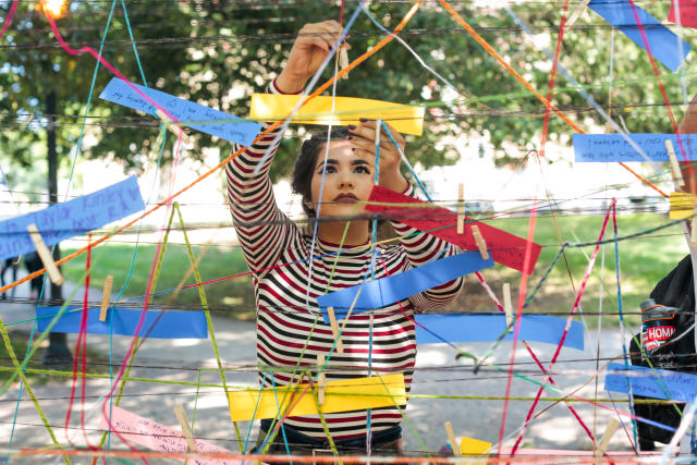 A student adding a note to a collection of mental health messages during annual RECESS event