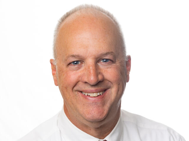David Wirt, a White man in a white dress shirt and red striped tie.
